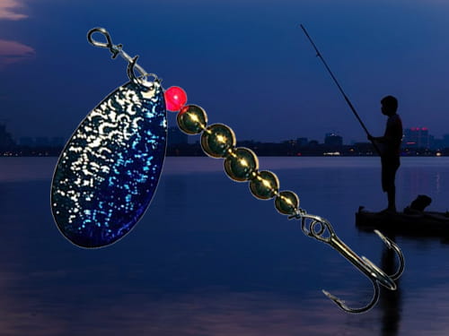 Thomas Lures Special Spinn inline spinner with a red bead and shiny dark blue blade. Man fishing off a dock and city skyline in the background.
