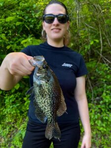 Rae of Kast Queens holding a beautiful crappie by the lip.